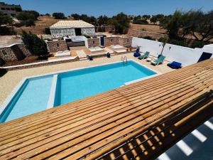 une grande piscine avec une terrasse en bois à côté d'une maison dans l'établissement Maison Luxueuse à Essaouira, à Essaouira