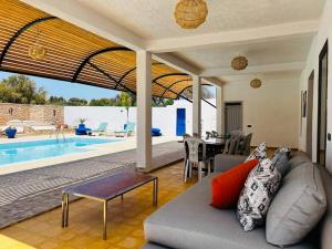 - un salon avec un canapé et une piscine dans l'établissement Maison Luxueuse à Essaouira, à Essaouira