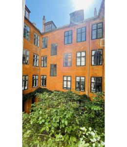 an old brick building with plants in front of it at ApartmentInCopenhagen Apartment 1541 in Copenhagen