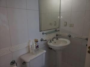 a white bathroom with a sink and a mirror at PREMIUM MENDOZA in Mendoza