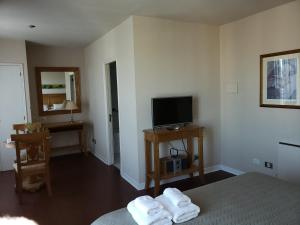 a bedroom with a bed and a tv and towels at PREMIUM MENDOZA in Mendoza