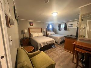 une chambre d'hôtel avec deux lits et un canapé dans l'établissement Vacationland Inn & Suites, à Brewer