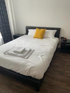 a white bed with two towels on top of it at Defining Luxury, Comfort& Class2 in Barking