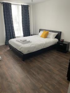 a bedroom with a bed and a wooden floor at Defining Luxury, Comfort& Class2 in Barking