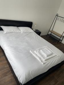 a large bed with white sheets and a black headboard at Defining Luxury, Comfort& Class2 in Barking