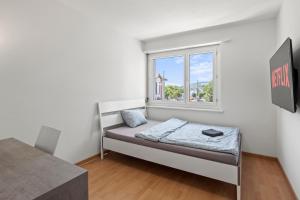a small bedroom with a bed and a window at Pearlstay - Spacious Excellent Connection Parking Washer in Winterthur