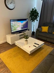 a living room with a tv and a white coffee table at Defining Luxury, Comfort& Class2 in Barking