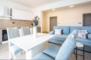a living room with a blue couch and a white table at Bepo Apartments at beach in Metajna