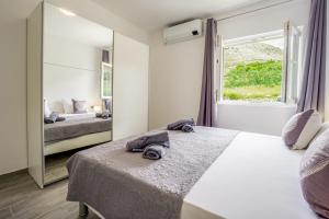 een slaapkamer met een groot bed en een spiegel bij Bepo Apartments at beach in Metajna