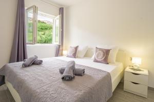 a bedroom with a bed with towels on it at Bepo Apartments at beach in Metajna