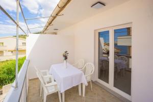 a dining room with a table and chairs on a balcony at Bepo Apartments at beach in Metajna