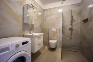 een badkamer met een wasmachine en een douche bij Bepo Apartments at beach in Metajna