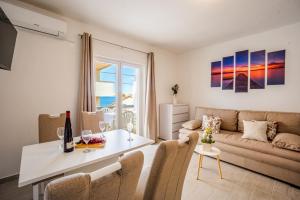 a living room with a couch and a table at Bepo Apartments at beach in Metajna