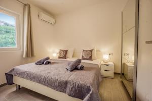 a bedroom with a large bed with two pillows on it at Bepo Apartments at beach in Metajna