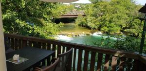 uma varanda com uma mesa e um rio com uma ponte em APARTMANI SRCE MREŽNICE em Duga Resa