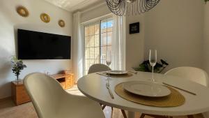 una sala da pranzo con tavolo e sedie bianchi di Modern 2 Bedroom Apt 200m to Beach Full Air Con a San Pedro del Pinatar