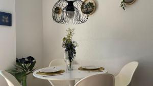 una mesa de comedor blanca con sillas y una lámpara de araña en Modern 2 Bedroom Apt 200m from Beach Full AirCon, en San Pedro del Pinatar