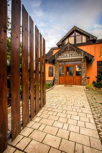 un edificio con una valla de madera delante de él en Vila Fenix B&B, en Ružomberok