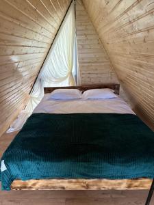 a bed in a tent with a green comforter at One day in the village/ერთი დღე სოფელში in Batumi