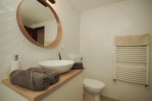 a bathroom with a sink and a toilet and a mirror at Gyulai idill apartman in Gyula