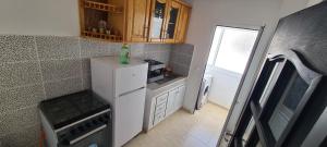 a small kitchen with a refrigerator with a bottle on it at Appartement Atlantique Beach in Tangier