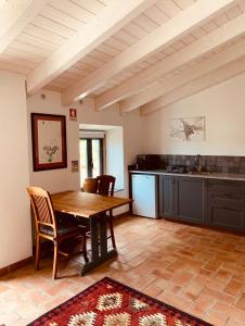 eine Küche mit einem Holztisch und Stühlen im Zimmer in der Unterkunft Casa na Colina : The Cottage and The Long House in São Brás de Alportel