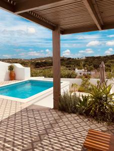 una piscina en un patio con pérgola en Casa na Colina : The Cottage and The Long House, en São Brás de Alportel