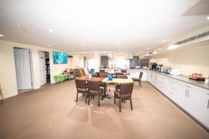 a kitchen and dining room with a table and chairs at Flushing Garden Hotel in Queens