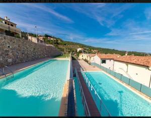 een groot zwembad met blauw water bij Appartamento incantevole con uso piscina e spa in Magliolo