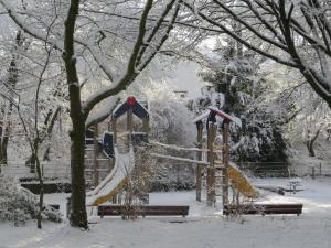 a playground covered in snow in a park at Ferienwohnung am Barbarossasee in Göppingen +13 photos