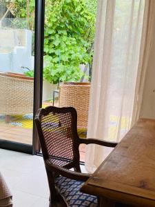 una sedia in legno seduta di fronte a una finestra di Chambre d hôte Entre Cigale et Pagnol a Peypin