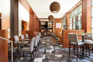 a dining room with tables and chairs and windows at The Westin Princeton at Forrestal Village in Princeton