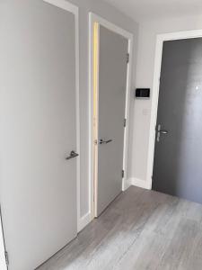 une chambre vide avec deux portes et du parquet dans l'établissement Executive Luxury stays 3, à Barking