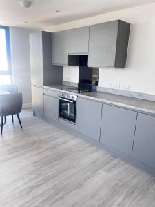 a kitchen with white cabinets and a stove top oven at Executive Luxury stays 3 in Barking