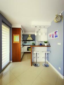 a kitchen with a counter and two bar stools at Apartament Morski z ogródkiem in Rumia