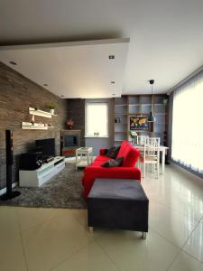 a living room with a red couch and a tv at Apartament Morski z ogródkiem in Rumia