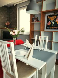 a dining room table with white chairs and a blue table and chairsktop at Apartament Morski z ogródkiem in Rumia