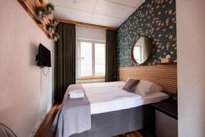 a small bedroom with a bed and a mirror at Hotel Auberge Nassau in Eindhoven