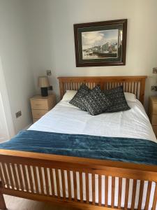 a bedroom with a wooden bed with two pillows at Wellington Cottage in Wexford