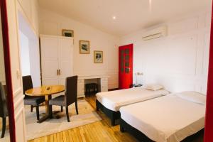 ein Hotelzimmer mit 2 Betten und einem Tisch in der Unterkunft Le Cocooning 974 Hôtel Restaurant Réunion in Antananarivo