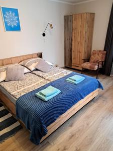 1 dormitorio con cama con sábanas azules y silla en Pensjonat W Ogrodzie, en Sterławki Wielkie