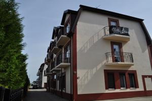 a building with a sign on the side of it at Villa Etiuda in Ustronie Morskie