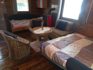 sala de estar con sillas de mimbre y sofá en EXIT Camping with bungalow, mobile home, tents, and empty spots with private acces to the beach en Novi Sad