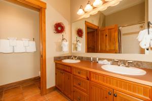 a bathroom with two sinks and a large mirror at Springs by Summit County Mountain Retreats in Keystone