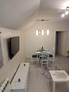 a living room with a table and a tv at Apartman MIVA in Bele Vode