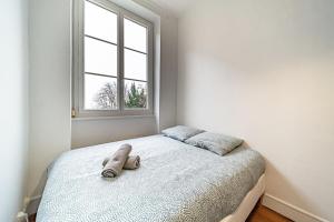 Bett in einem weißen Zimmer mit Fenster in der Unterkunft Le Bon Pasteur-cosy 2 pers- Croix Rousse in Lyon
