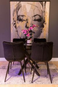 einen Tisch mit zwei Stühlen vor einem Gemälde in der Unterkunft The Harbour Apartment 2 in Hamburg
