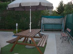 a picnic table with an umbrella and a bench at studio 66 in Caumont-sur-Durance
