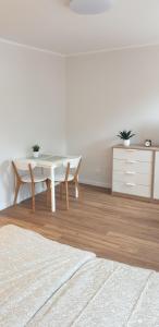 een witte eetkamer met een witte tafel en stoelen bij Apartament przy Starym Mieście in Elblag
