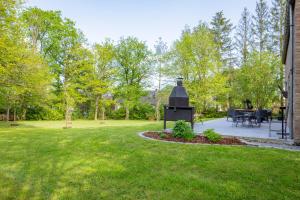 a backyard with a grill in the grass at Villa VALY 4 adultes et 2 enfants in Durbuy